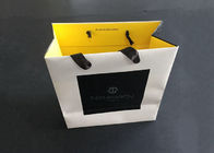 I sacchi di carta stampati regalo della maniglia del nastro portano il giallo bianco dell'interno del nero impermeabile al grasso fornitore